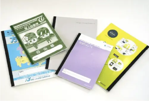 表紙の色やデザインが異なる5冊のノートが広げられている。